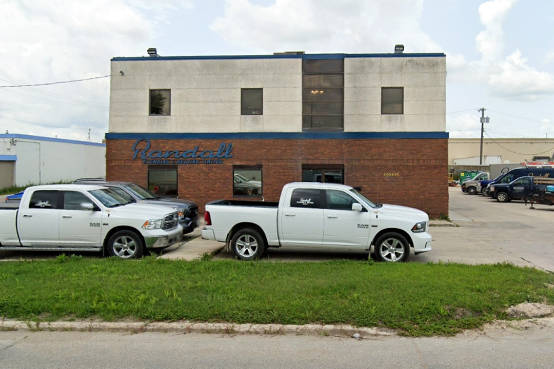 Randall Plumbing and Heating office building with parked white trucks.